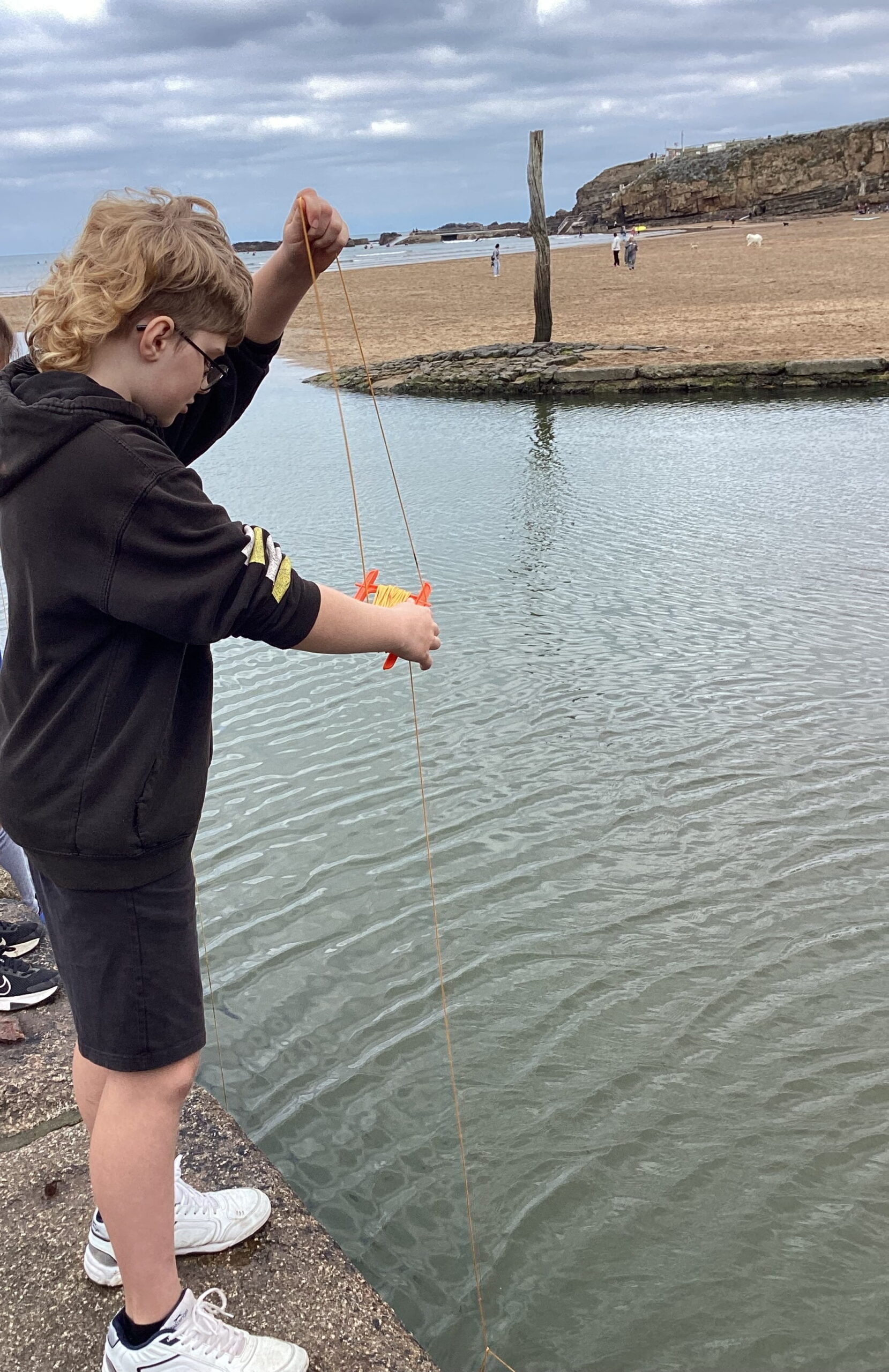Learners enjoying a crabbing activity at a local beach, exploring marine life and developing their understanding of the coastal environment.