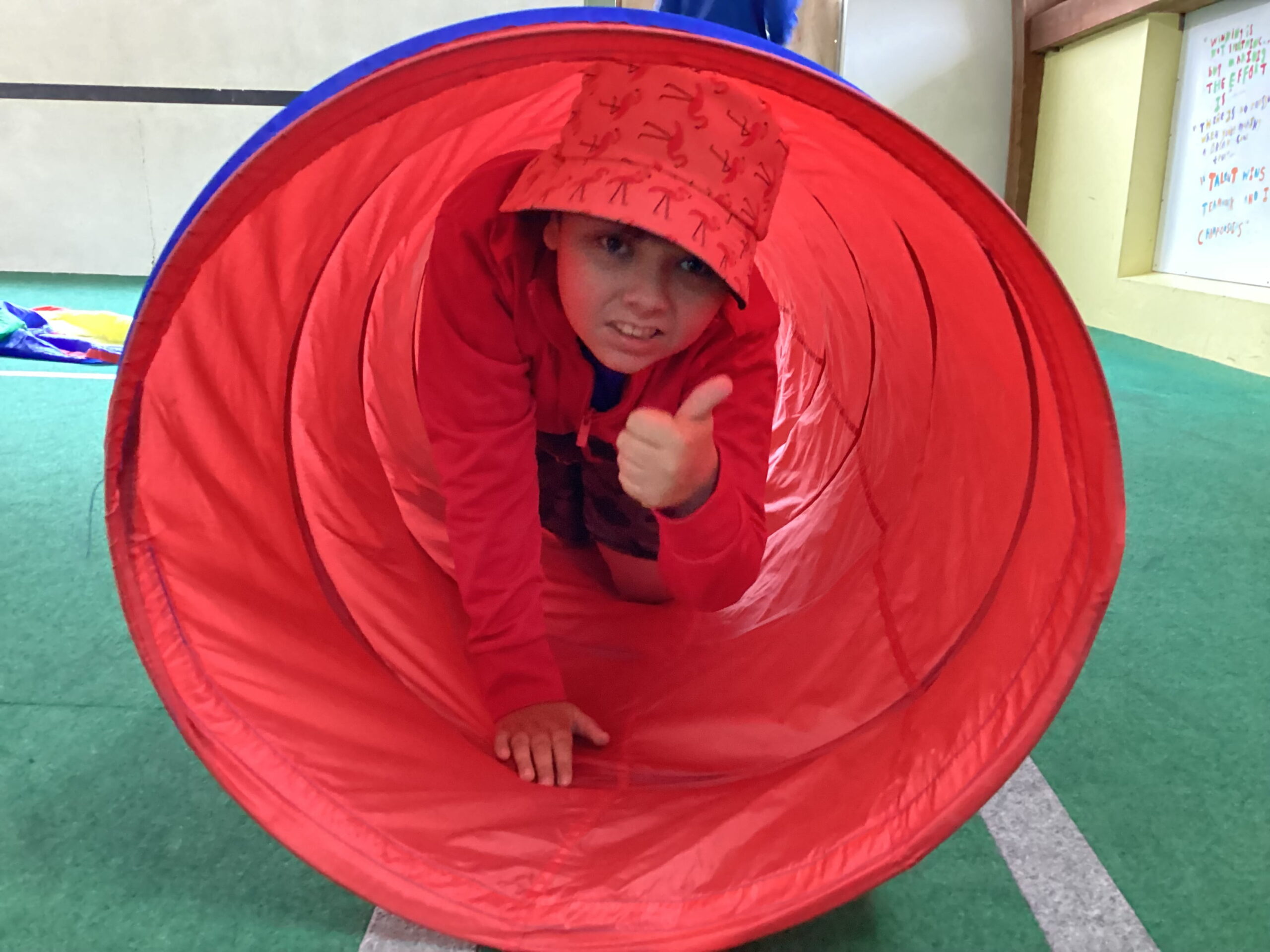 A learner making their way through the tunnel during Sensory Circuits, developing coordination, balance, and body awareness.