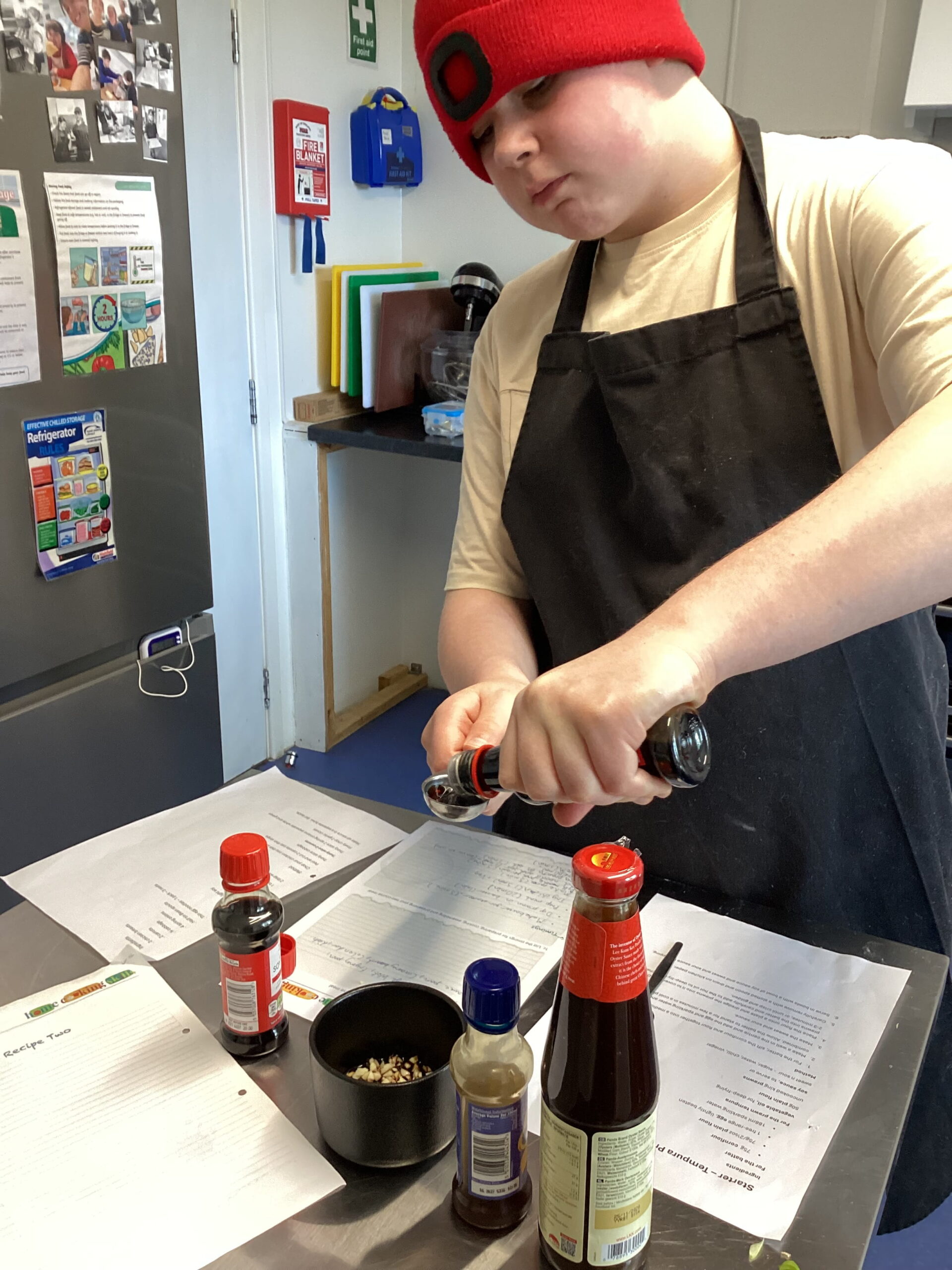 A learner carefully following a recipe as part of their BTEC cooking assessment, demonstrating their food preparation and cooking skills.